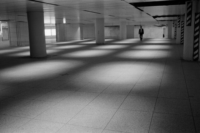 Black and white: an empty underground concourse with squares of light on the floor
