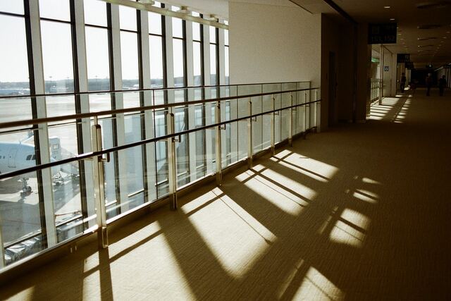 Sunlight through a glass corridor casting long stripes of shadow