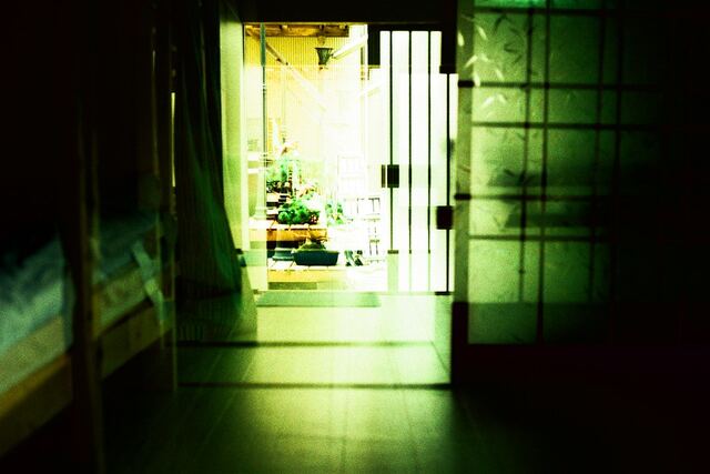 A corridor lit in green, double exposed